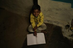 Smiling Boy Sitting with Notebook